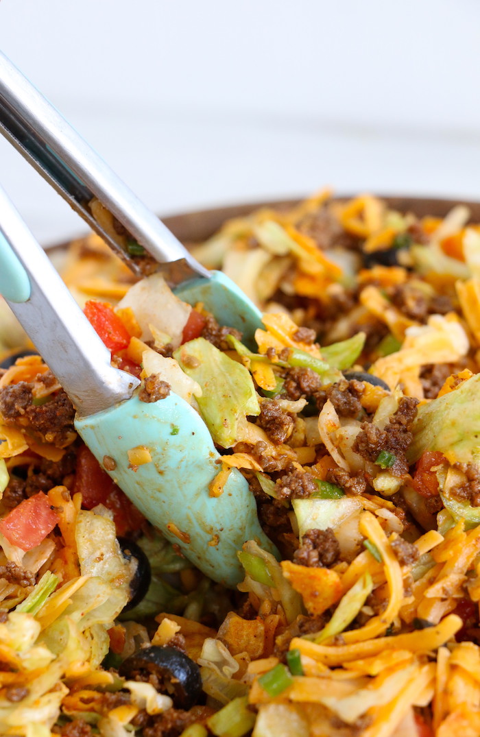 Dorito Taco Salad - This crunchy and zesty salad is made with seasoned ground beef, veggies, cheese and Doritos, then tossed with Catalina dressing. So delicious and serves a crowd!