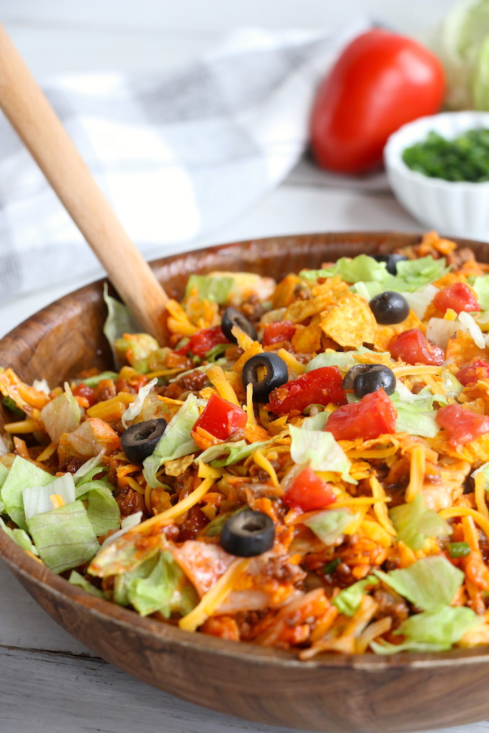 Dorito Taco Salad - This crunchy and zesty salad is made with seasoned ground beef, veggies, cheese and Doritos, then tossed with Catalina dressing. So delicious and serves a crowd!