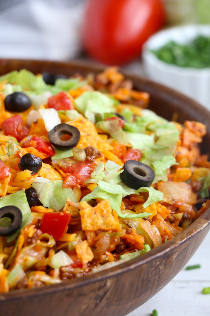 Dorito Taco Salad - This crunchy and zesty salad is made with seasoned ground beef, veggies, cheese and Doritos, then tossed with Catalina dressing. So delicious and serves a crowd!