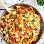 Dorito Taco Salad - This crunchy and zesty salad is made with seasoned ground beef, veggies, cheese and Doritos, then tossed with Catalina dressing. So delicious and serves a crowd!