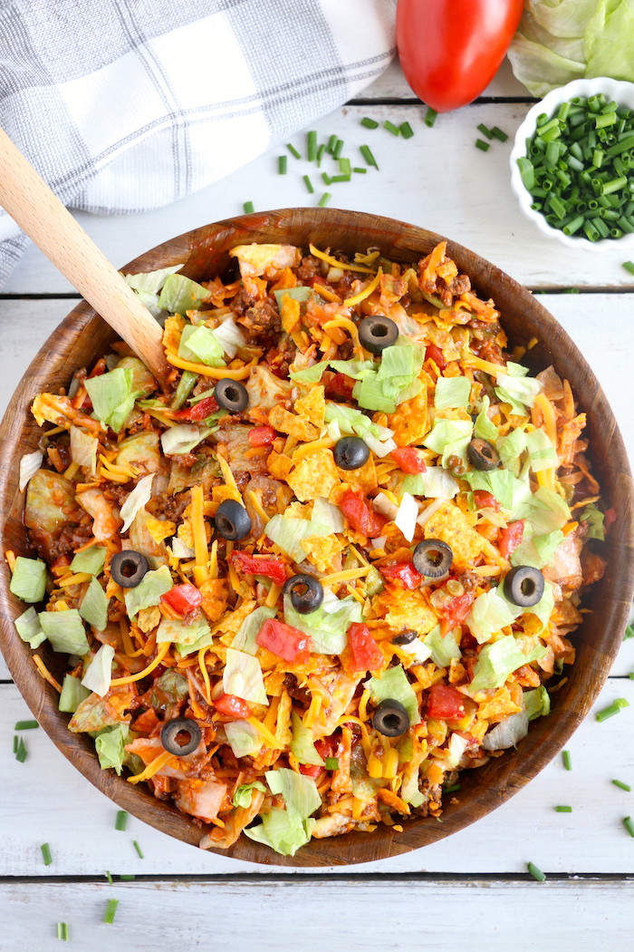 Dorito Taco Salad - This crunchy and zesty salad is made with seasoned ground beef, veggies, cheese and Doritos, then tossed with Catalina dressing. So delicious and serves a crowd!