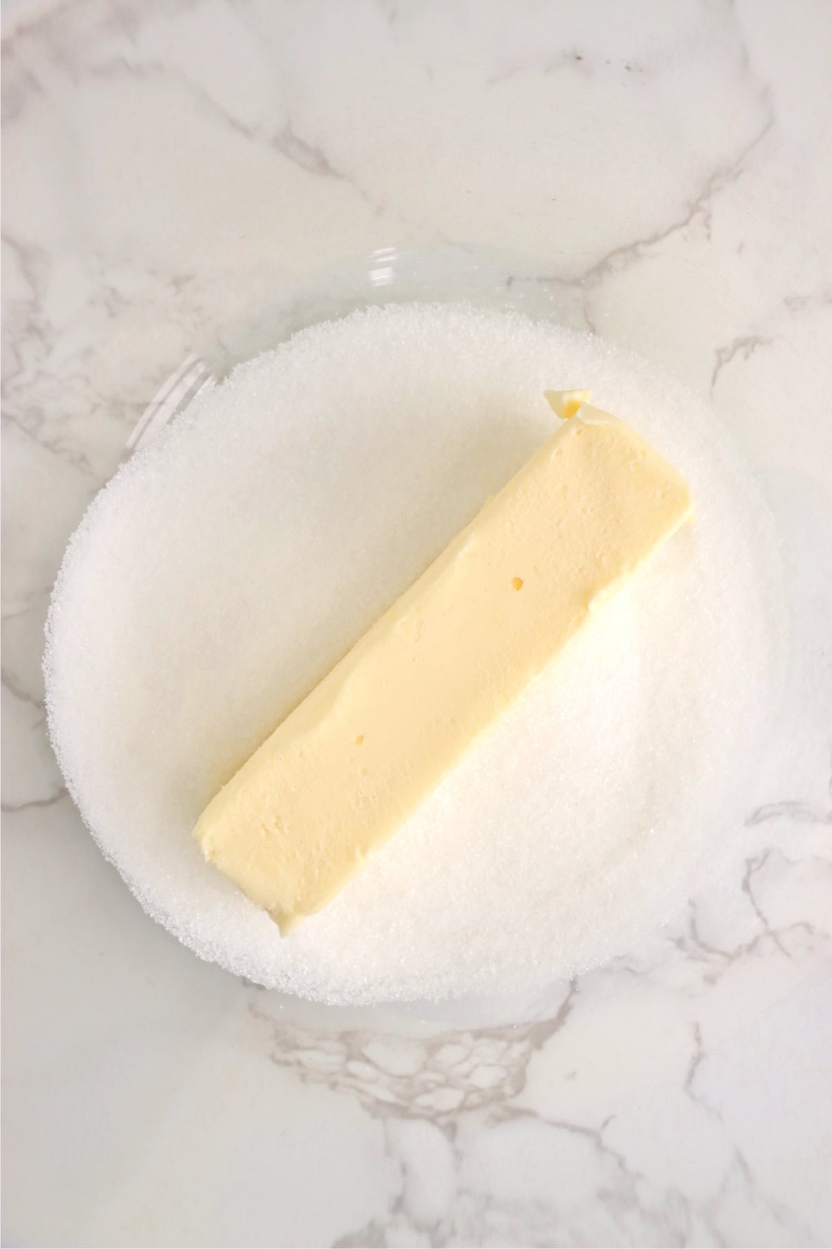 Stick of butter and sugar in a mixing bowl