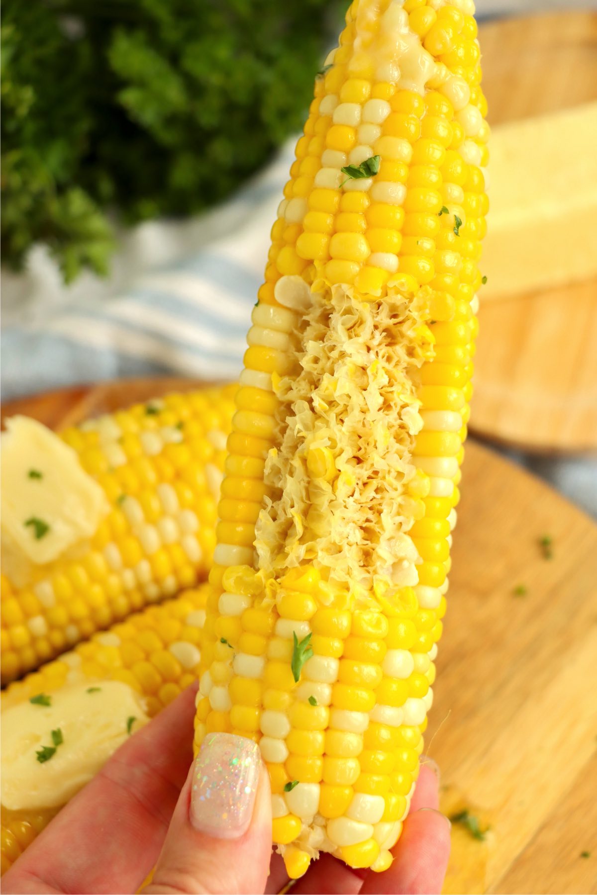 hand holding up a half eaten cob of corn