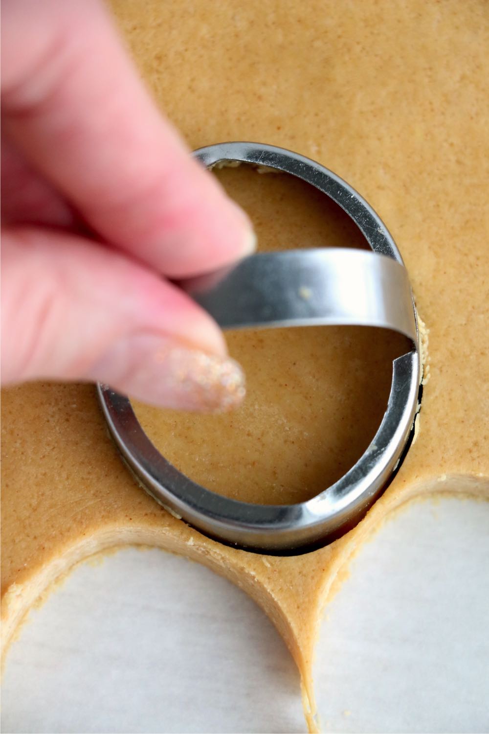 using an egg-shaped cookie cutter to cut out dough