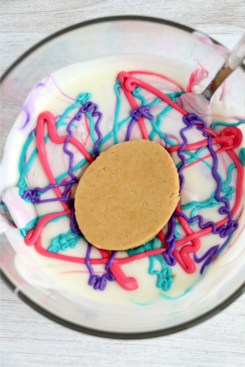 dipping a peanut butter egg into a marbling mixture