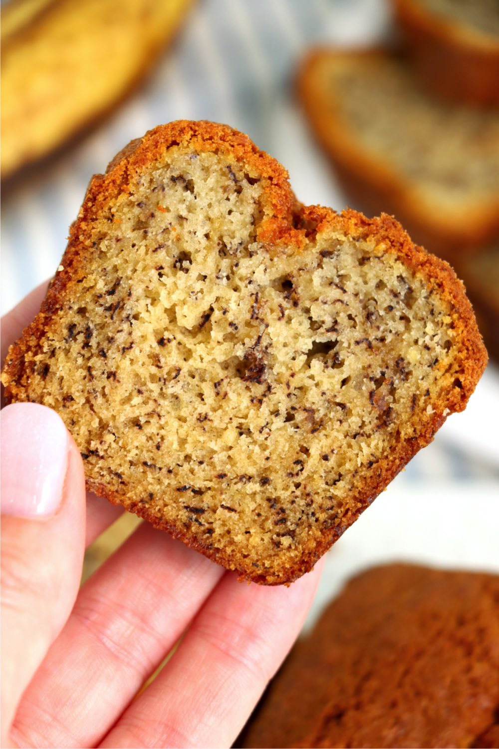 holding a piece of banana bread