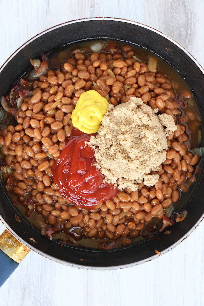 ketchup, mustard and brown sugar in pan of baked beans