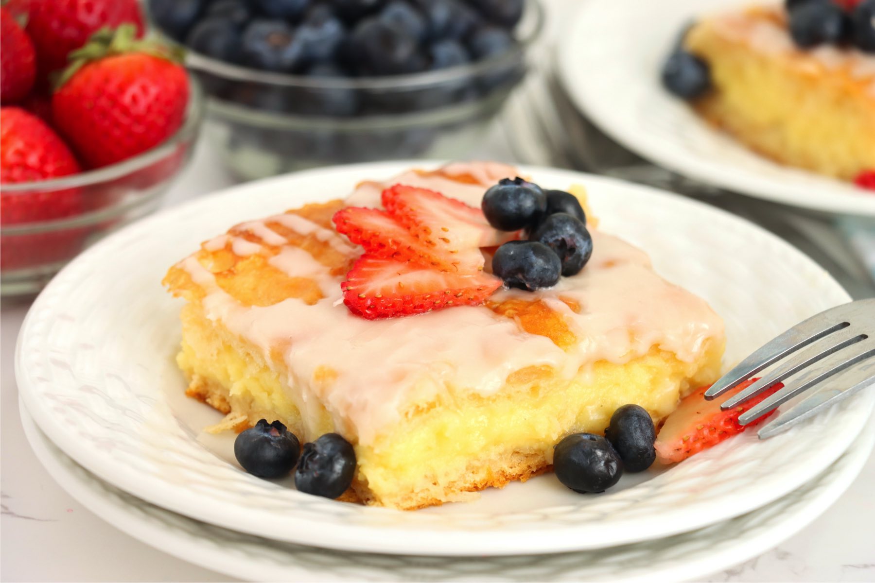fruit topped cheese danish on a white plate