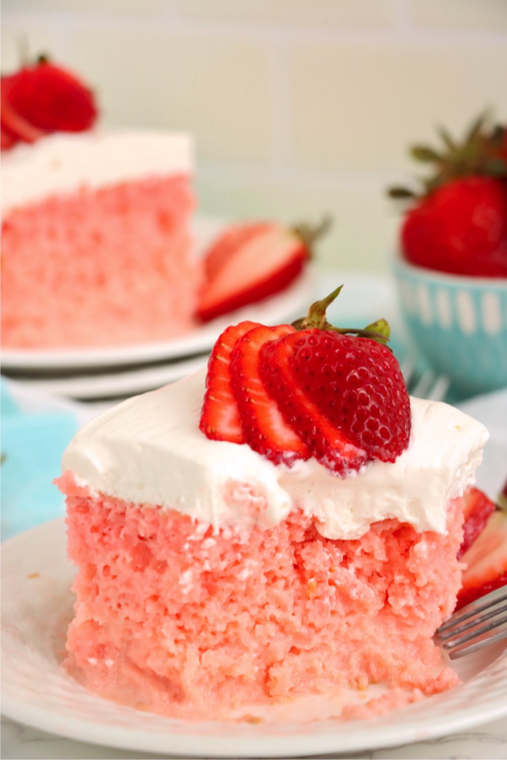 Fork digging into a piece of strawberry tres leches cake