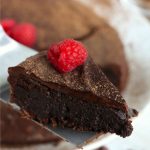 piece of flourless chocolate cake on cake server