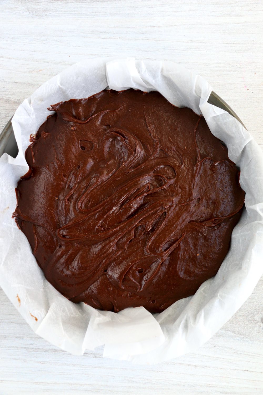 parchment paper lined pan with chocolate batter inside