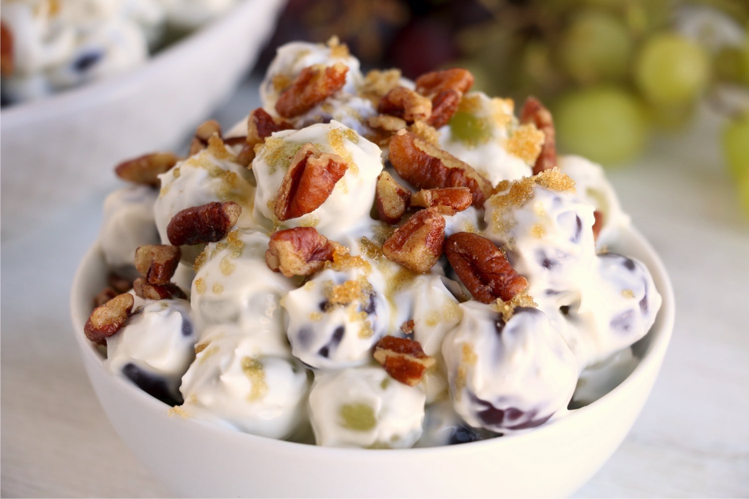 small bowl of grape salad covered in nuts