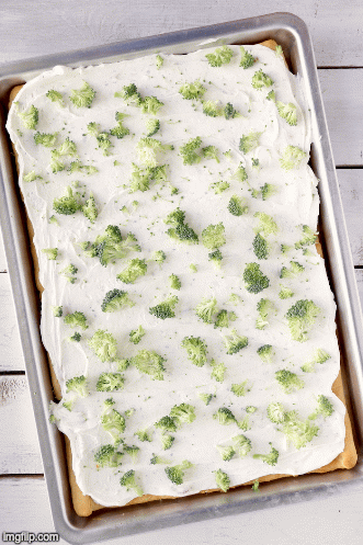 Halloween Veggie Pizza - A spooky themed graveyard pizza featuring a flavorful ranch cream cheese covered crust, topped with colorful veggies and "tombstone" crackers.