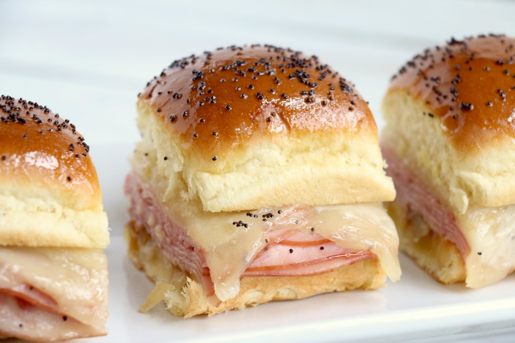 Ham and Cheese Sliders -Hawaiian rolls filled with ham, cheese, onions and a delicious mustard sauce, then brushed with butter. A great appetizer to feed a crowd!