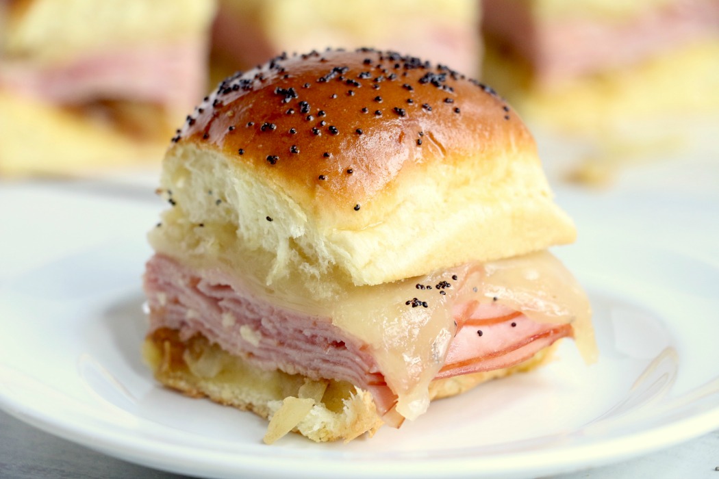 Ham and Cheese Sliders -Hawaiian rolls filled with ham, cheese, onions and a delicious mustard sauce, then brushed with butter. A great appetizer to feed a crowd!