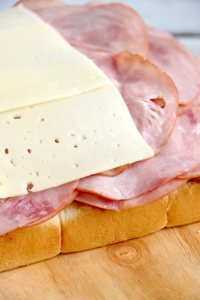 Ham and Cheese Sliders -Hawaiian rolls filled with ham, cheese, onions and a delicious mustard sauce, then brushed with butter. A great appetizer to feed a crowd!