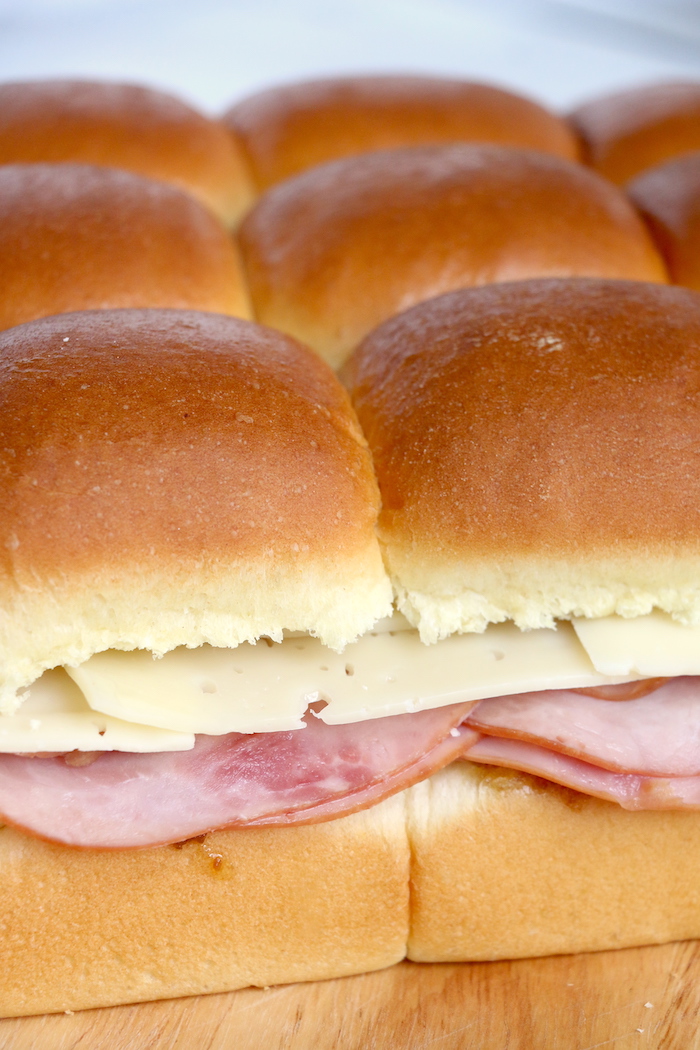 Ham and Cheese Sliders -Hawaiian rolls filled with ham, cheese, onions and a delicious mustard sauce, then brushed with butter. A great appetizer to feed a crowd!