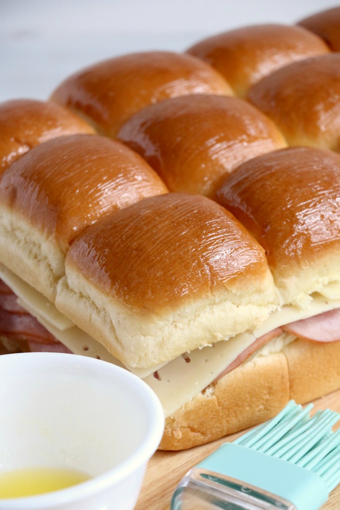 Ham and Cheese Sliders -Hawaiian rolls filled with ham, cheese, onions and a delicious mustard sauce, then brushed with butter. A great appetizer to feed a crowd!