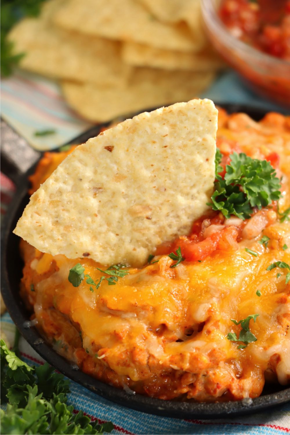 tortilla chip sticking out of warm bean dip