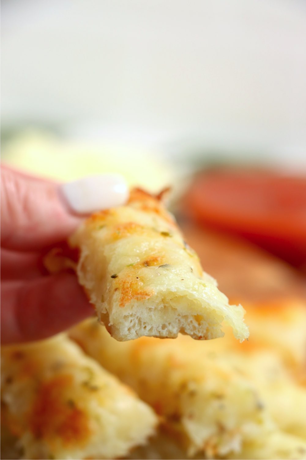 hand holding a half-eaten breadstick