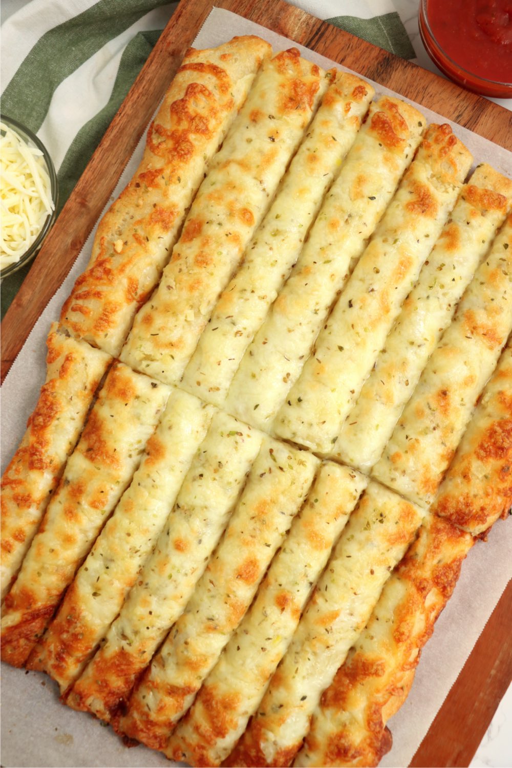 Cheesy breadsticks cut on a cutting board