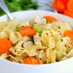 chicken noodle soup in white bowl with spoon