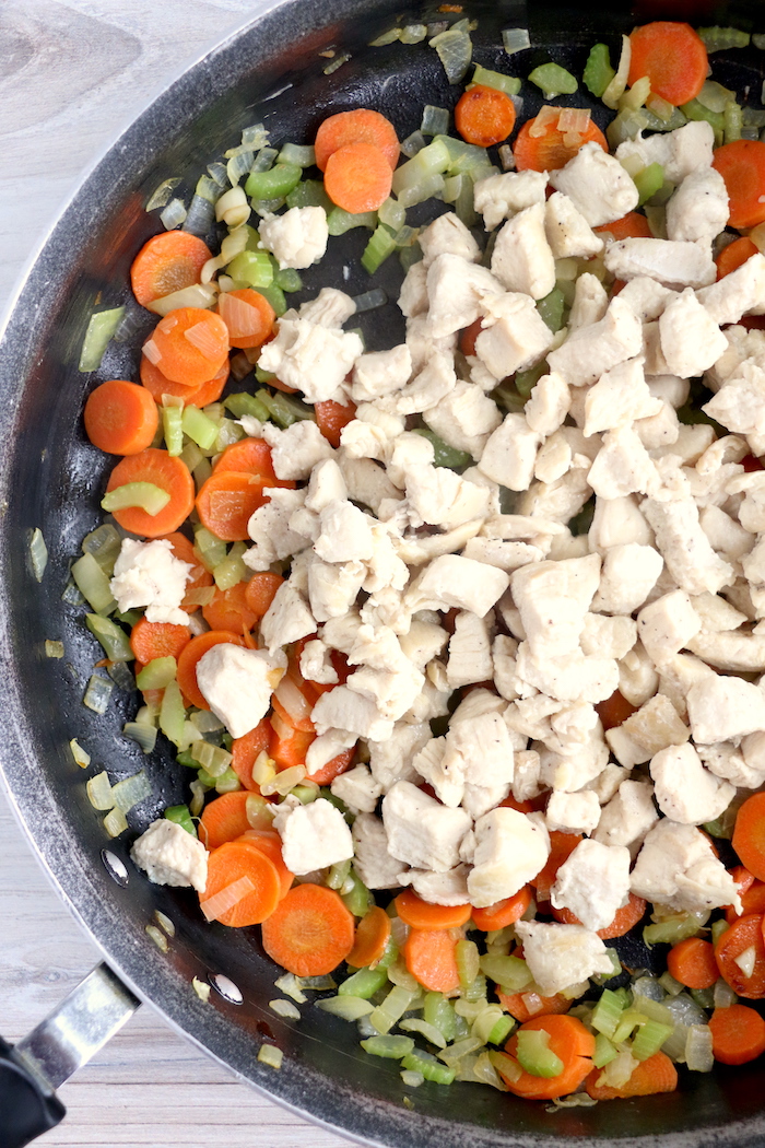 diced chicken on top of carrots, celery and onions