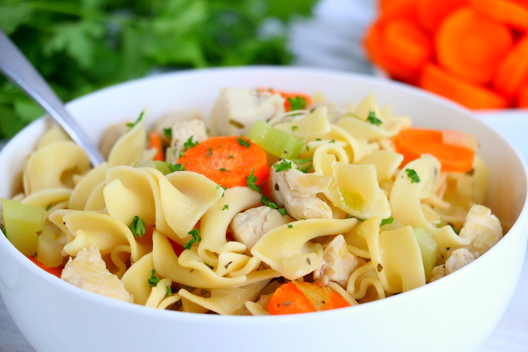 bowl of chicken noodle soup in bowl with spoon