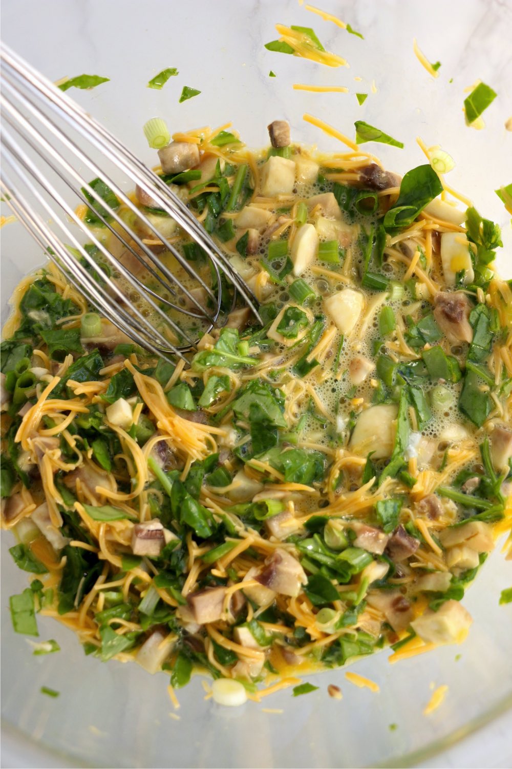 whisking eggs and veggies together