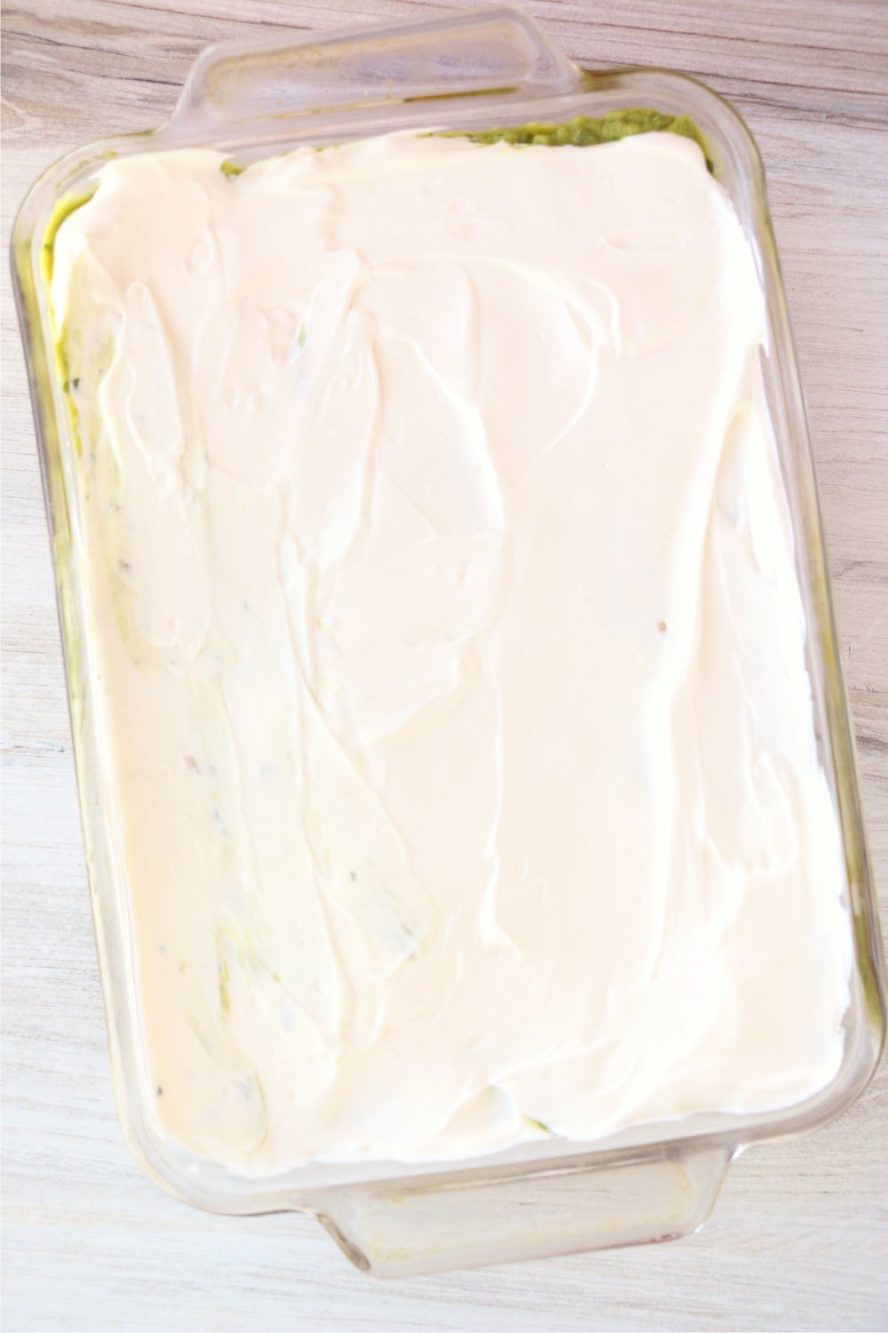 layer of sour cream spread in glass baking pan