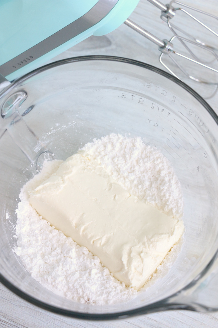 Cream cheese and powdered sugar in a glass mixing bowl