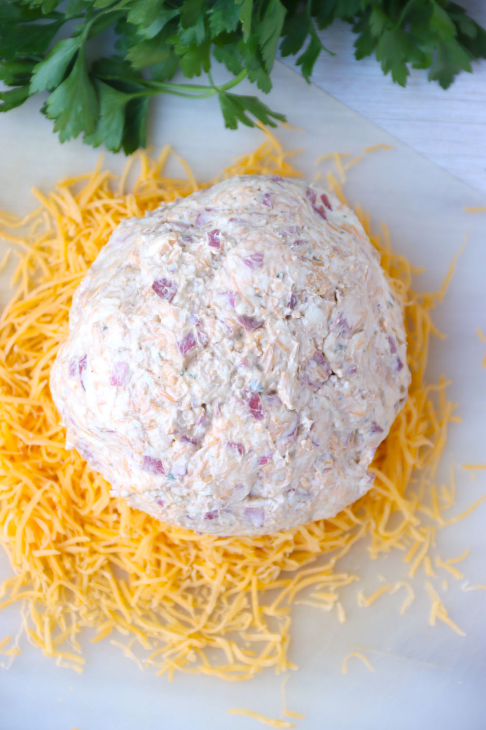 cheese ball sitting on top of pile of shredded cheese