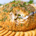 digging into cheese ball with a spreader knife