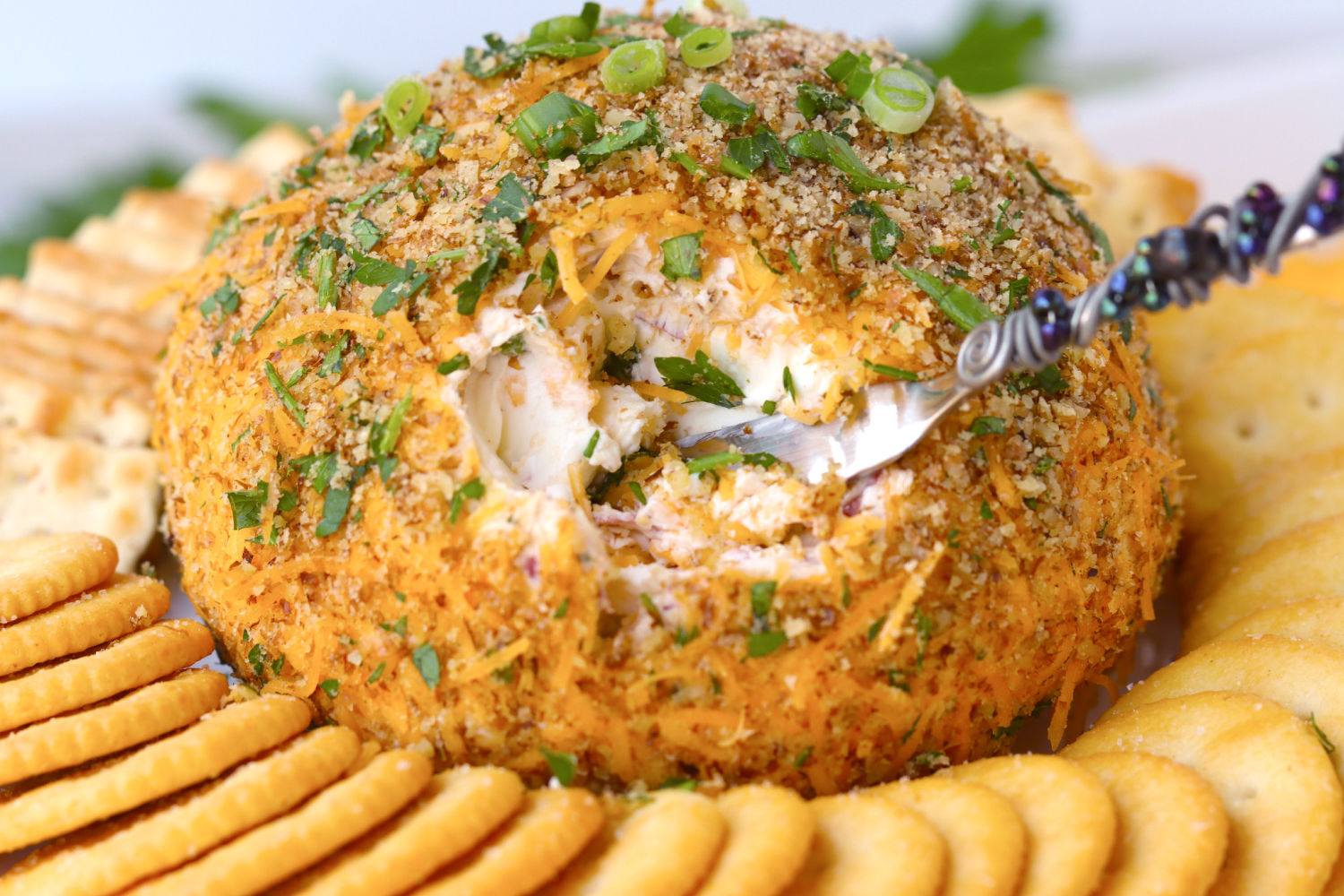 digging into cheese ball with a spreader knife