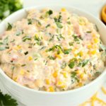 bowl of corn dip surrounded by chips and fresh ingredients
