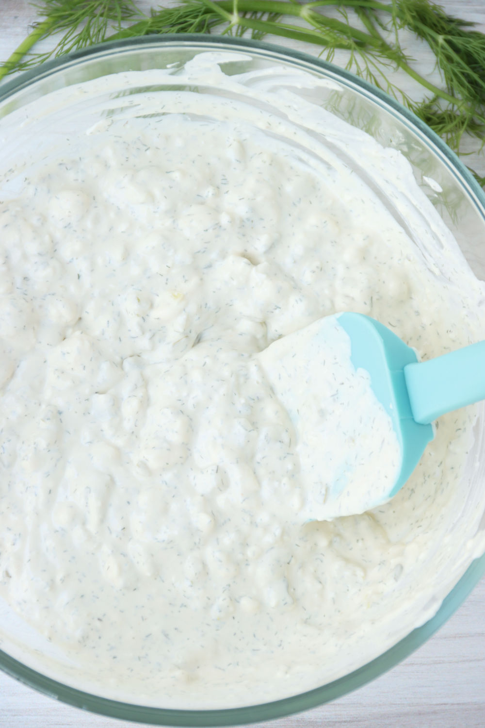 Mixing dill pickle dip in a bowl