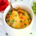 spoon in a mug of diced veggies and eggs