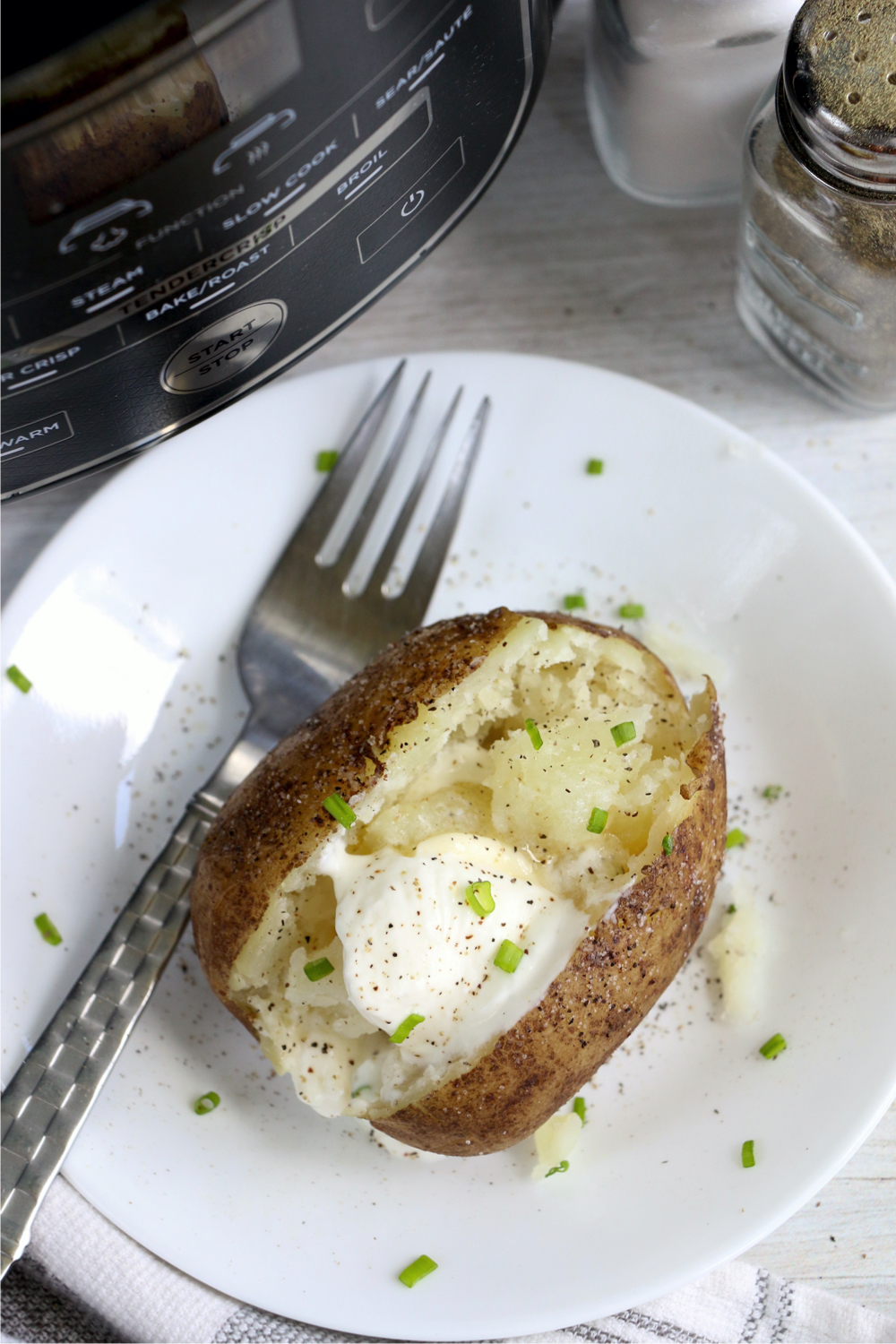 baked potato on a plate with a fork