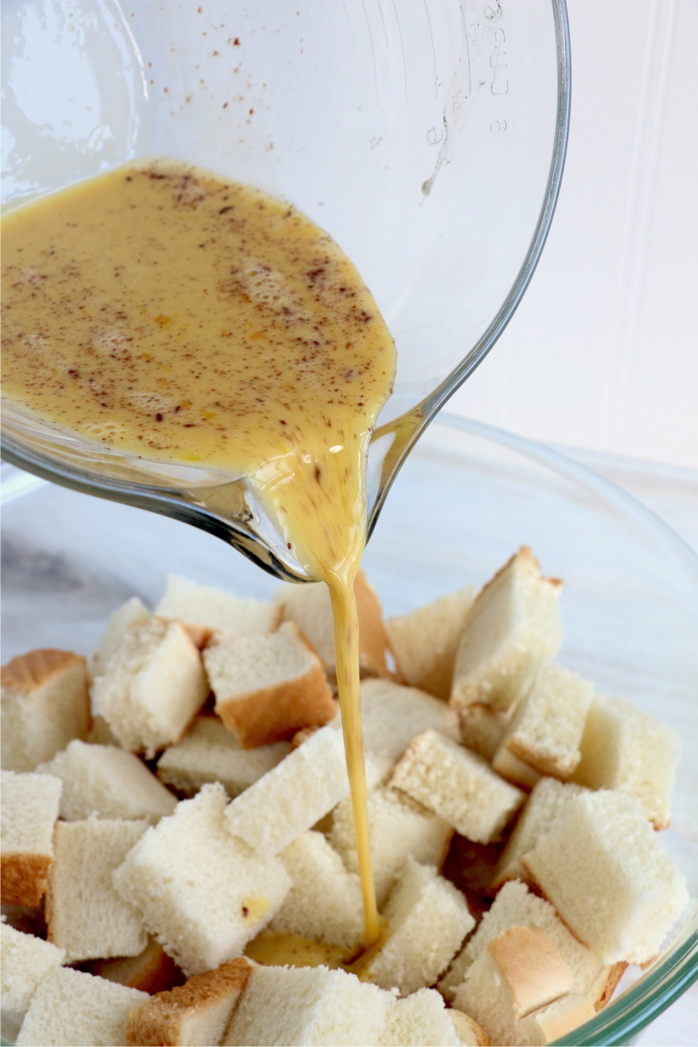 Pouring wet ingredients over pieces of bread