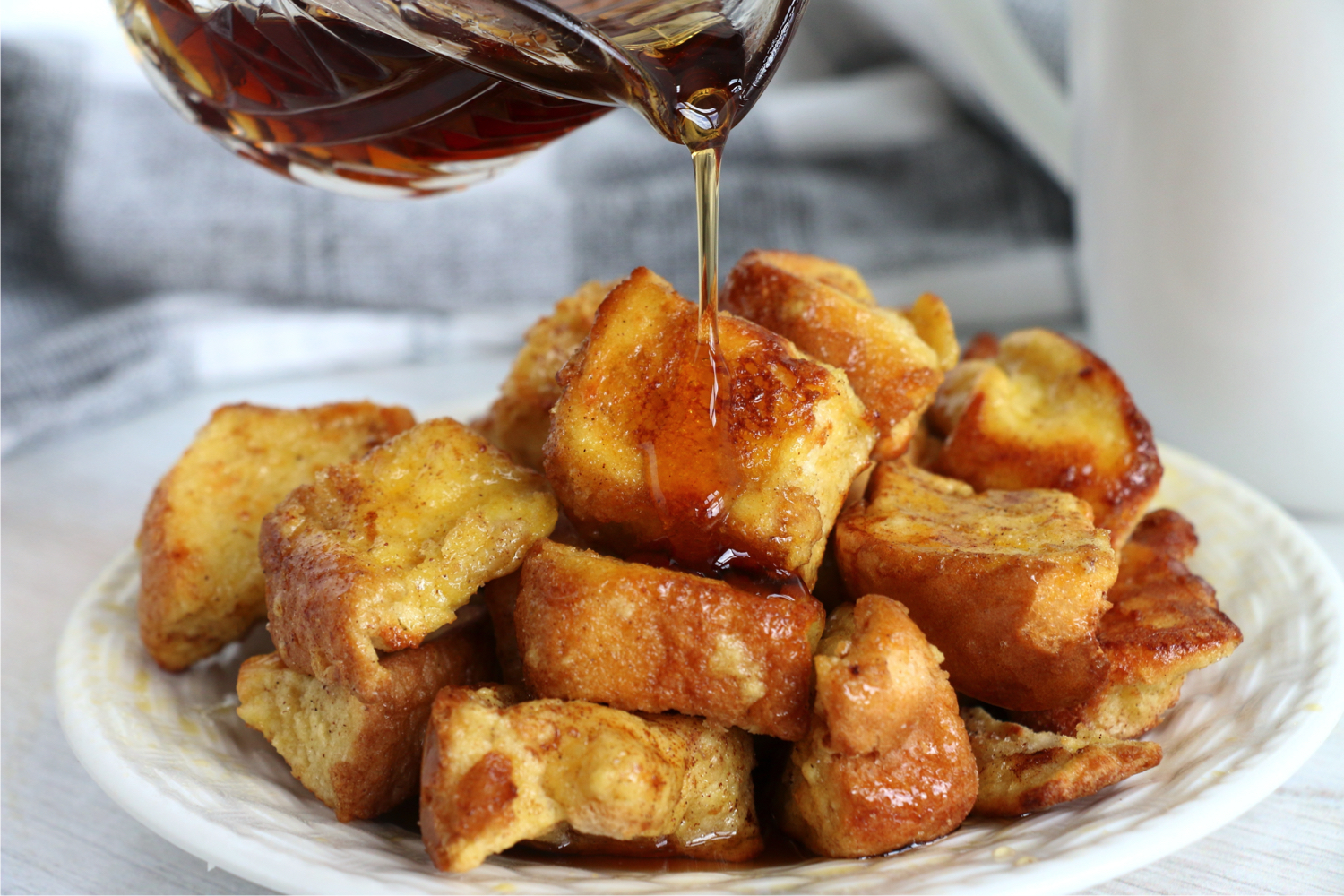 pouring syrup on pieces of french toast