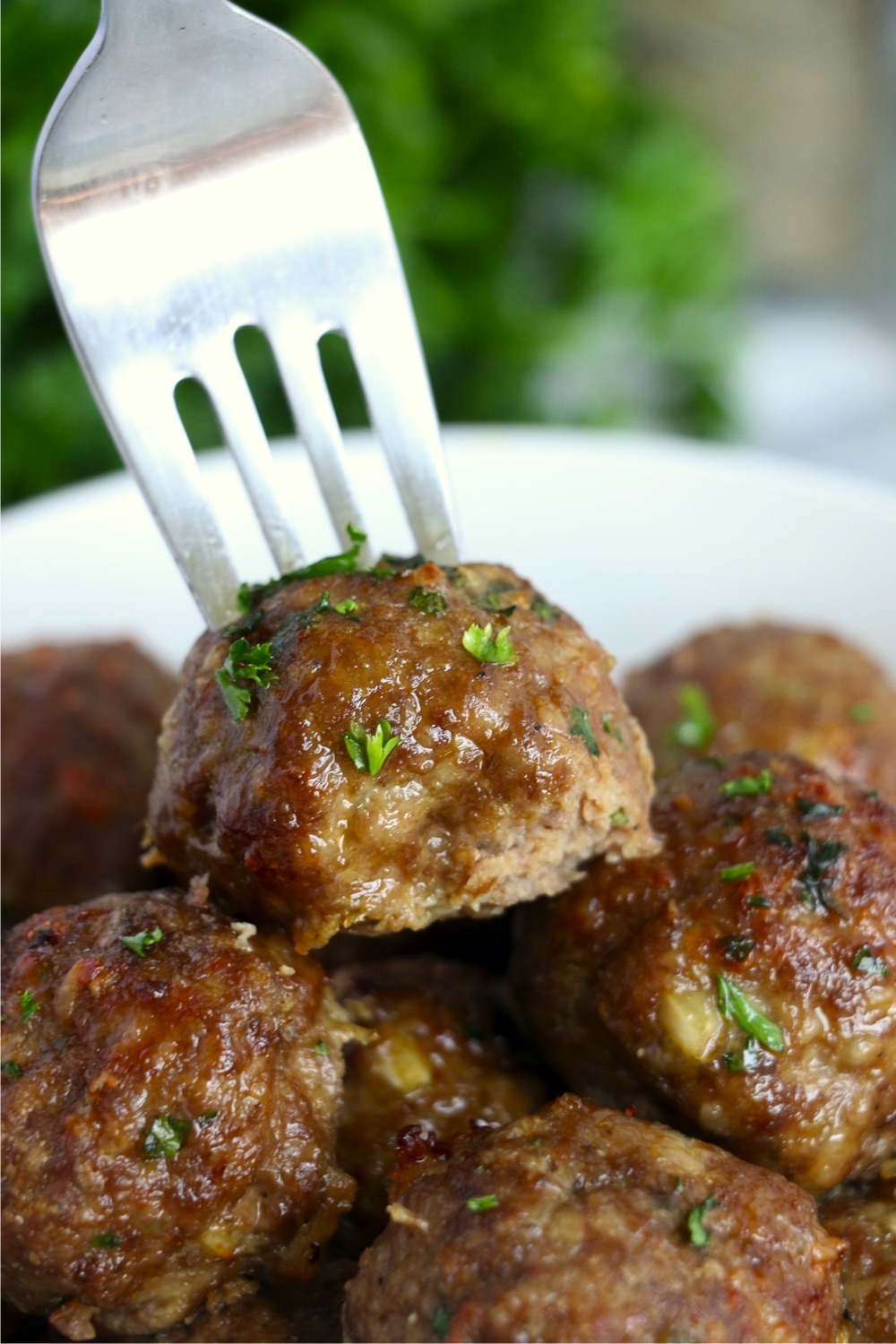 Fork picking up meatball in bowl