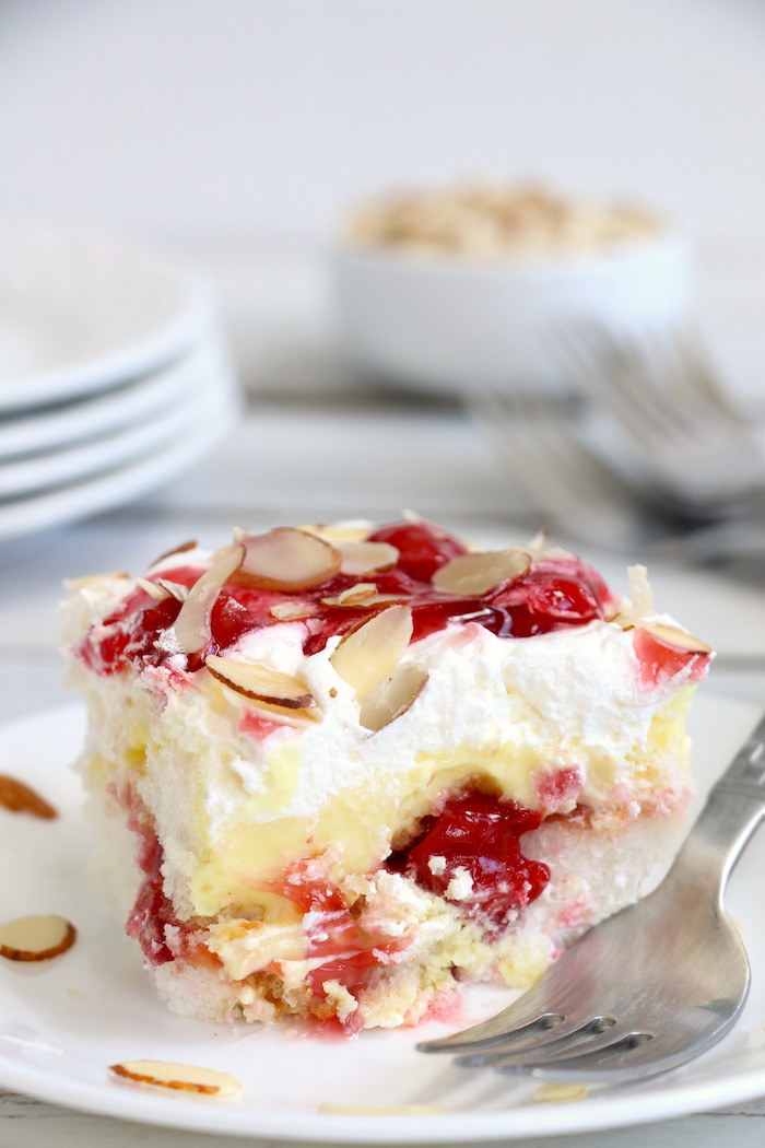No Bake Cherry Dump Cake - An easy, no-bake cherry trifle dessert with layers of angel food cake, sour cream, pudding, cherry pie filling and whipped topping.