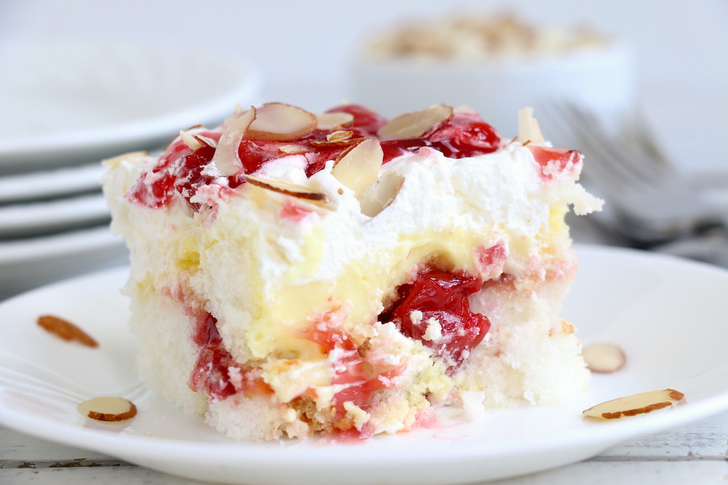 No Bake Cherry Dump Cake - An easy, no-bake cherry trifle dessert with layers of angel food cake, sour cream, pudding, cherry pie filling and whipped topping.