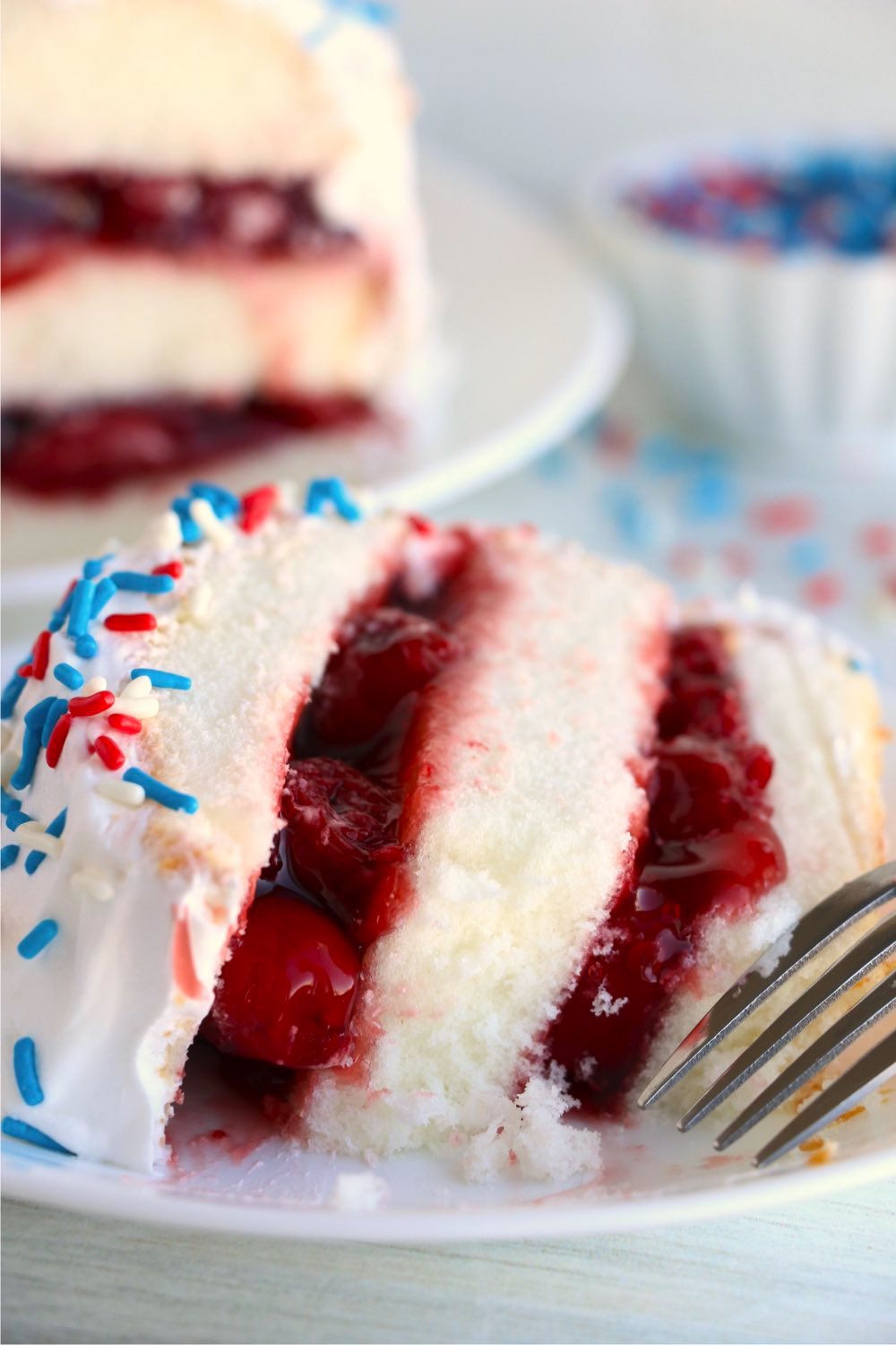 Slice of layered cherry torte on a plate