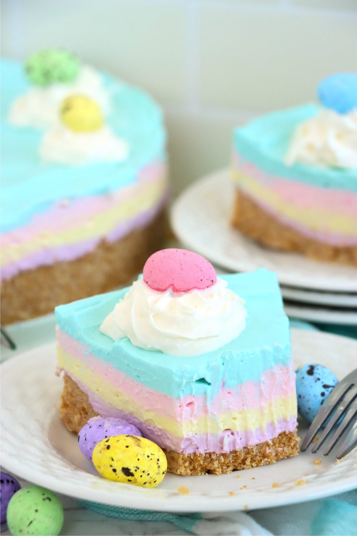 Piece of pastel-layered cheesecake with a bite taken out