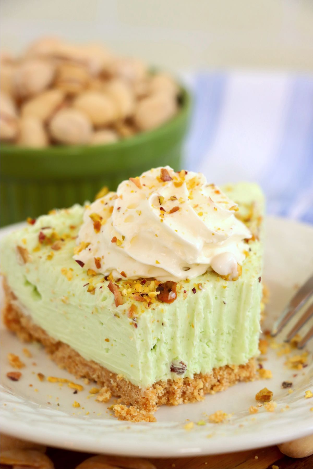 Bite taken out of a piece of pistachio cheesecake