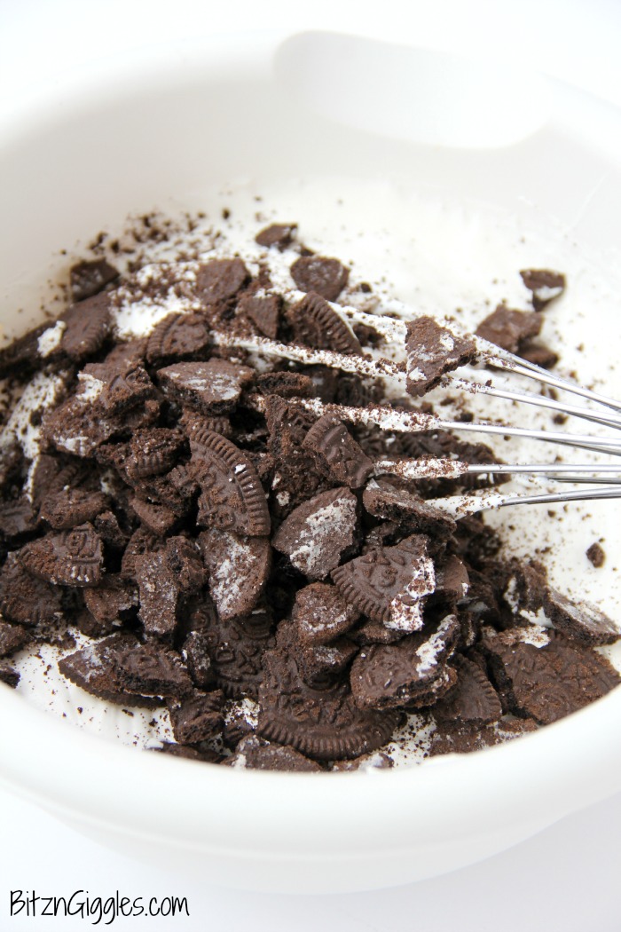 White Chocolate Oreo Pudding Poke Cake - A super moist vanilla cake with an Oreo cookie bottom, Oreo-infused center and cookie fluff frosting.