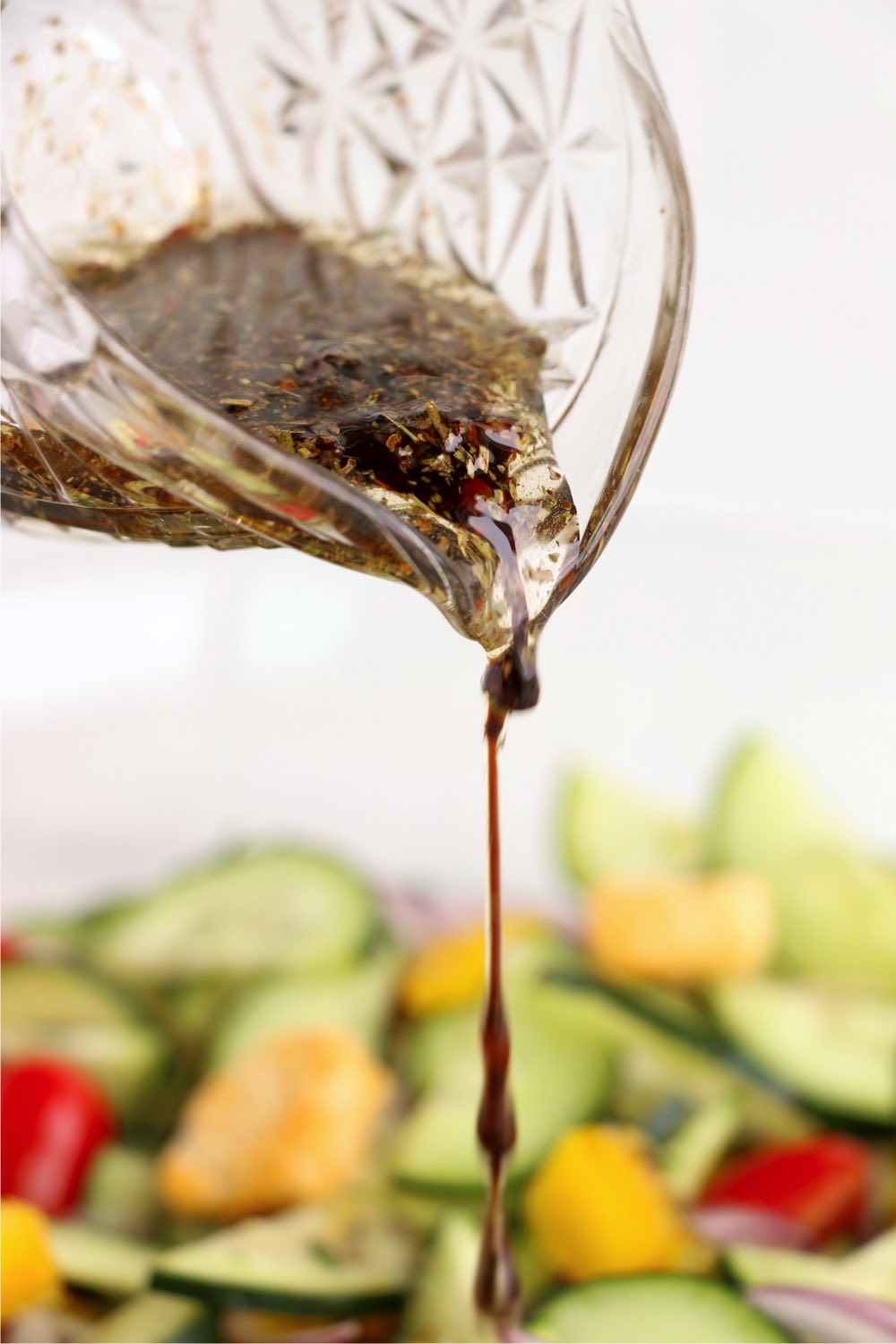 pouring balsamic dressing over salad