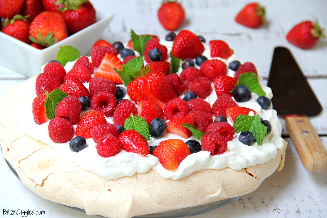 Triple Berry Pavlova - This meringue cake is crisp on the outside and soft and light on the inside! Topped with homemade whipped cream and fresh berries, it's such an elegant, light and delicious dessert!