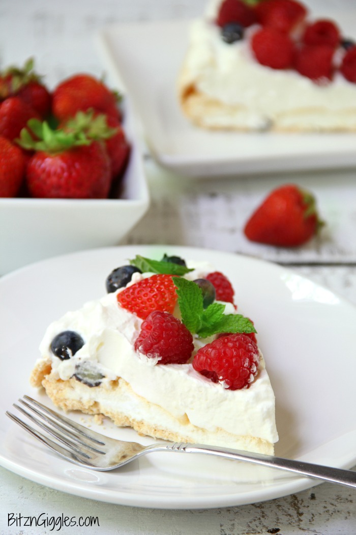 Triple Berry Pavlova - This meringue cake is crisp on the outside and soft and light on the inside! Topped with homemade whipped cream and fresh berries, it's such an elegant, light and delicious dessert!